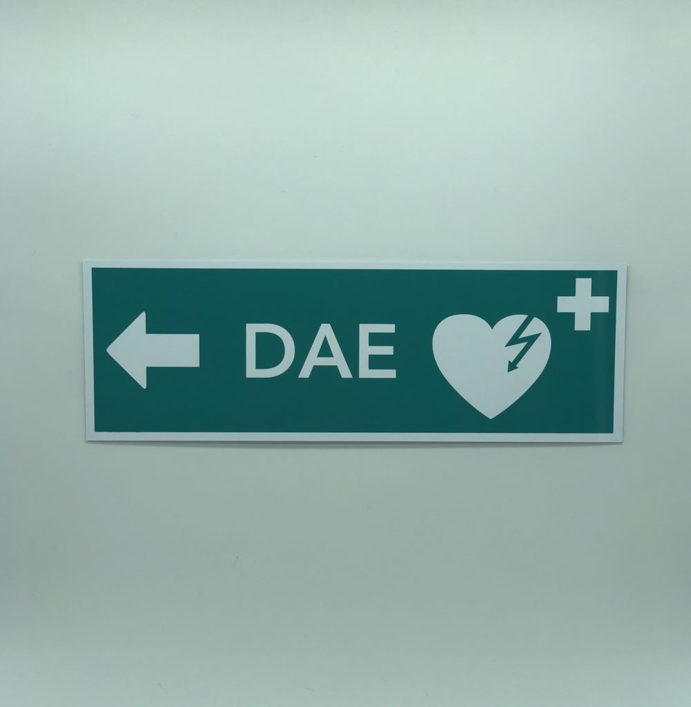 panneau de signalisation qui indique que le DAE ou défibrillateur est à gauche