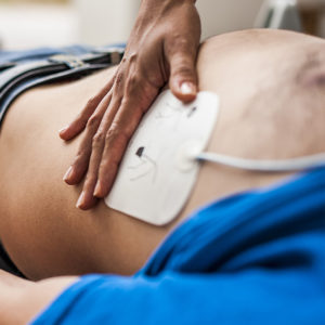 Homme allongé victime d'une crise cardiaque avec des électrodes posées sur lui, les électrodes sont des accessoires défibrillateurs
